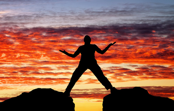 Силуэт человека на фоне заката огненного неба
 - Фото, изображение