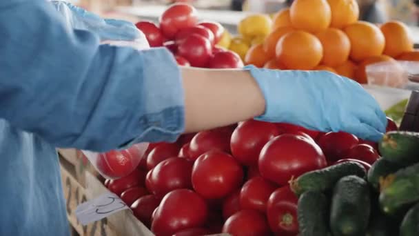 Uma mulher de luvas compra tomates no mercado, close-up
 - Filmagem, Vídeo