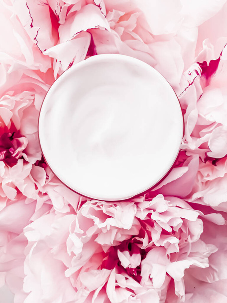 Gezicht crème moisturizer op bloemen achtergrond als luxe huidverzorging cosmetica, gezondheidszorg en beauty product - Foto, afbeelding