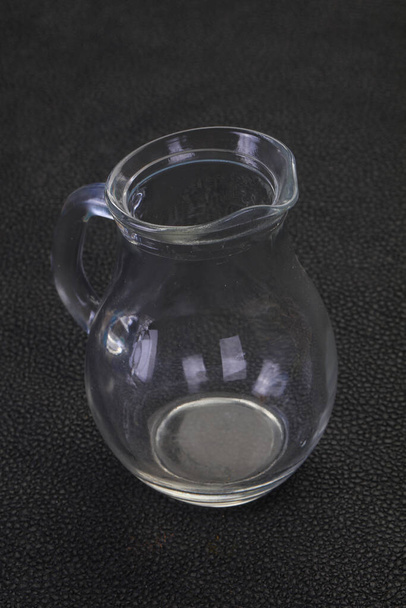 Empty glass jug over black background - Photo, Image