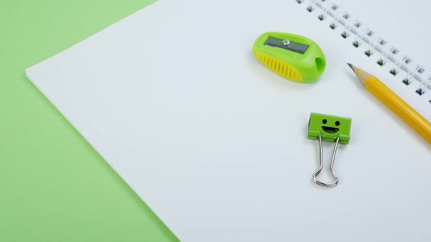 Yellow Pencil and Green Smile Binder Clip on School Notepad - Footage, Video