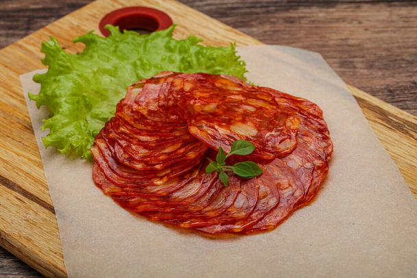 Le tradizionali salsicce di maiale Chorizo servite con foglie di basilico - Foto, immagini