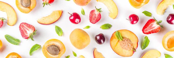 Καλοκαιρινό φόντο με φρέσκα φρούτα και μούρα σε λευκό φόντο. Σύνολο από διάφορα εποχιακά φρούτα και μούρα - φράουλα, βερίκοκα, ροδακινί φέτες, κεράσι, μέντα. Επίπεδη. Έννοια καλοκαιρινών φρούτων.  - Φωτογραφία, εικόνα