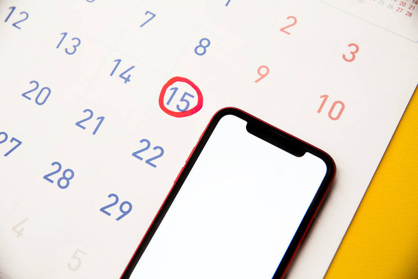 Calendario femenino con ovulación recordatorio en gráfico y smartphone. Seguimiento del ciclo menstrual y el concepto de ovulación - Foto, imagen