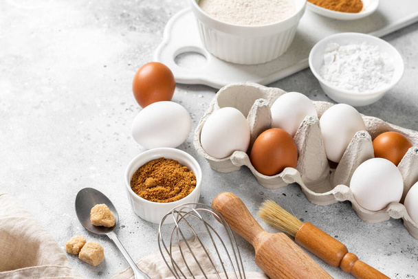 Ingredients for baking on a culinary background. Eggs, flour, cinnamon, sugar, soda on the kitchen table. Concept of preparation for baking. Top view with space for text - Photo, Image