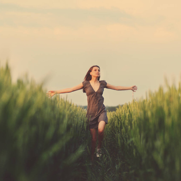 Happy woman running in the green field - Foto, Imagen