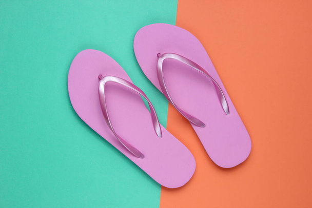 Trendy beach pink flip flops on coral blue paper background. Top view - Photo, Image