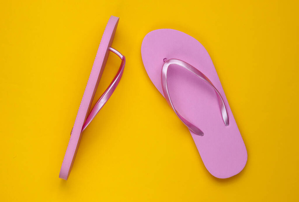 Trendy beach pink flip flops on yellow paper background. Top view - Photo, Image
