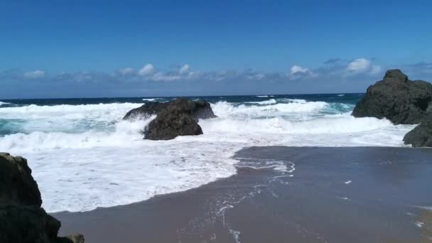 Waves hitting the rocks and generating foam on Bakio beach on a sunny summer day at noon - Footage, Video
