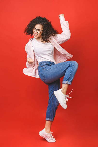 Full length size dreamy charming cheerful leisure lifestyle student lady jumping isolated over red background wear in casual.  - Fotoğraf, Görsel