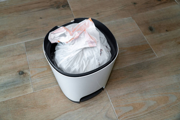 Top view of a bin with a plastic bag. Garbage bin in the kitchen. - Фото, изображение