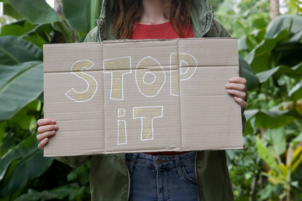 Femme blanche tenant STOP IT panneau en carton. Concept pacifique de protestation militante
. - Photo, image