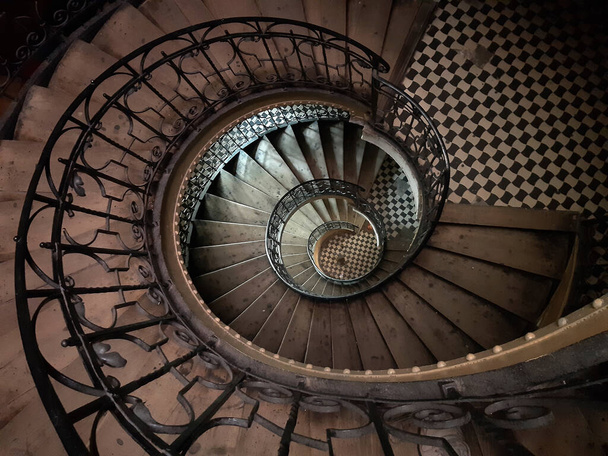 Вітряні спіральні сходи в старому європейському будинку. Верхній вид, темне світло.. - Фото, зображення