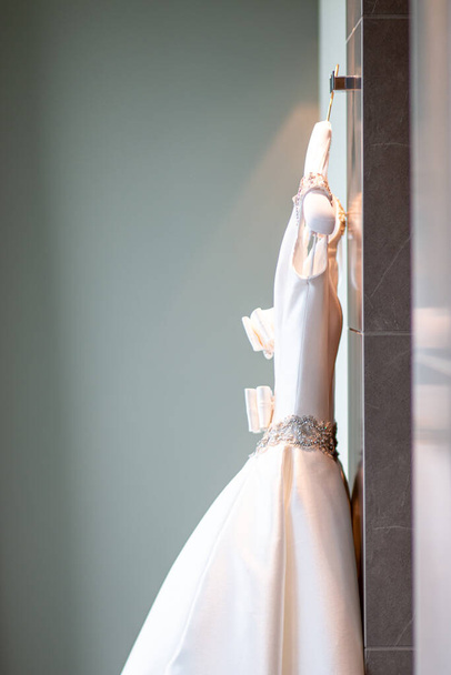 νυφικό φόρεμα νυφικό φόρεμα κρεμαστό φόρεμα κρεμάστρα ετοιμάζεται - Φωτογραφία, εικόνα