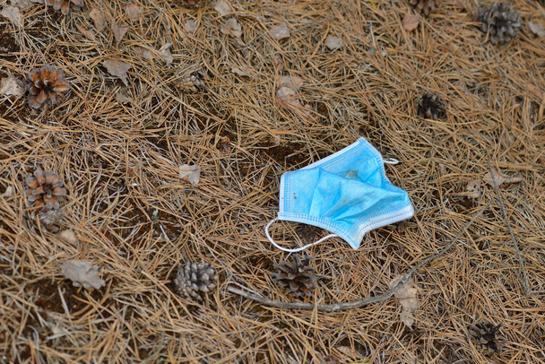Mouth protection mask thrown away in the forest - Photo, Image
