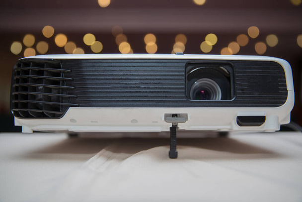 Close up projector in conference room . LCD Projector technology video presentation and home Entertainment object . mini led projector on wood table in a room projector home theater idea and concept - Photo, Image