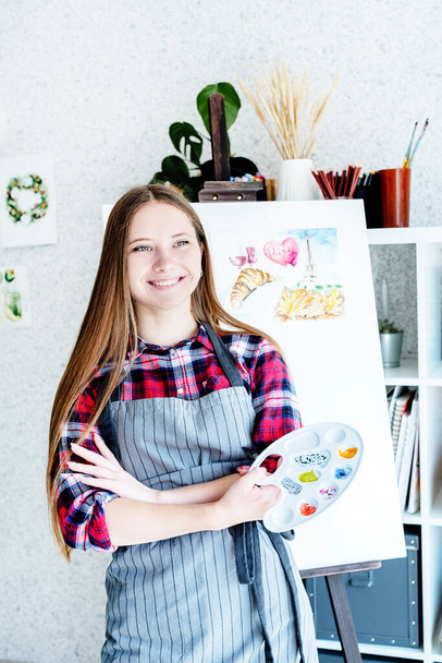 Jeune femme artiste tenant palette de couleurs travaillant dans son atelier
 - Photo, image