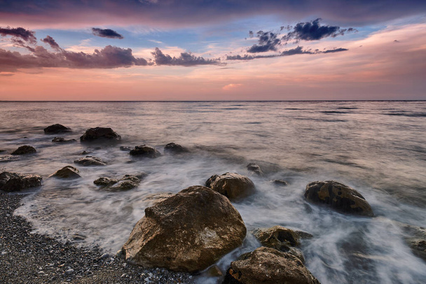 Niesamowity krajobraz wschodu słońca na morzu. Kolorowy widok rano dramatyczne niebo, krajobraz morski i skała. Długa ekspozycja. Grecja. Morze Śródziemne. Koncepcja środowiska naturalnego. - Zdjęcie, obraz