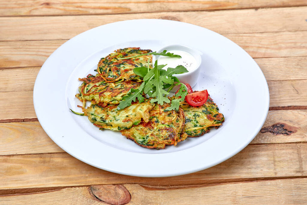 pancakes with zucchini and herbs on white plate, close view  - Photo, Image