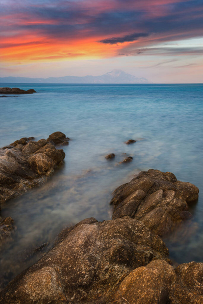 Εκπληκτικό ηλιοβασίλεμα στη Χαλκιδική, Παραλία Καρύδι, χερσόνησος Σιθωνία, Βουρβουρού, Ελλάδα, Ευρώπη. Δραματική βραδινή θαλασσογραφία της Μεσογείου. Θέα της φανταστικής βραχώδους ακτής. Έννοια του περιβάλλοντος. - Φωτογραφία, εικόνα
