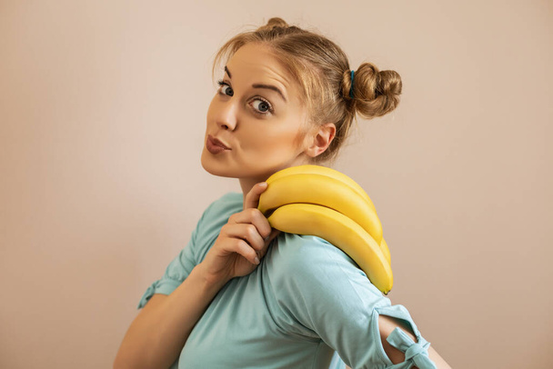 Portrait of cute happy woman holding bananas.Toned image. - 写真・画像