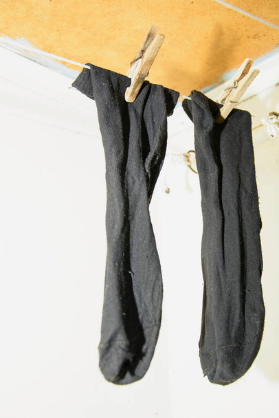 A mosott zoknik szárazon száradnak a ruhaszárítón. - Fotó, kép