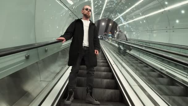 Człowiek idzie na schodach ruchomych na stacji metra - Materiał filmowy, wideo