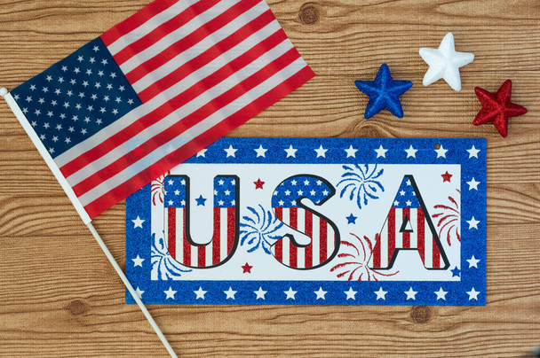 День независимости 4 июля, День Президента, День Памяти, День Ветерана, Великая Америка. Знак США в цветах флага США на деревянном фоне со звездами и флагом
 - Фото, изображение