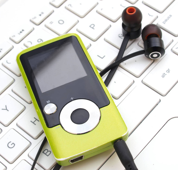 mp3 ψηφιακή συσκευή αναπαραγωγής μουσικής πάνω από πληκτρολόγιο laptop - Φωτογραφία, εικόνα