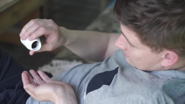 Homem derramando pílulas marrons em sua mão
 - Filmagem, Vídeo
