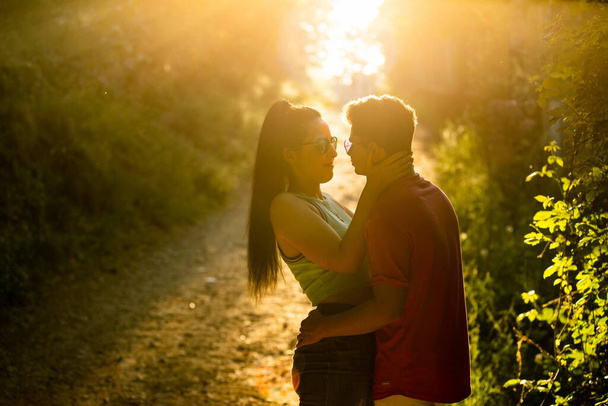 κορίτσι και αγόρι αγκαλιάζονται το ηλιοβασίλεμα - Φωτογραφία, εικόνα