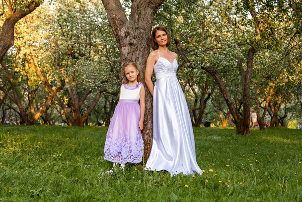 Bride and girl stand by the tree - Foto, immagini