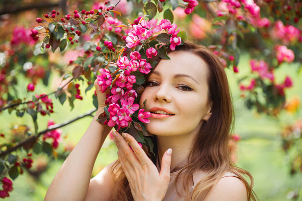 portrait of a beautiful young woman with make-up near a tree with flowers - Fotoğraf, Görsel