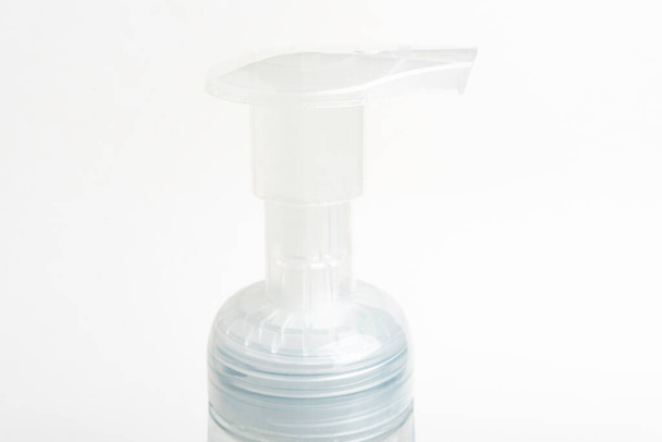 Eine Nahaufnahme der transluzenten Oberpumpe eines Schaumseifenflaschenspenders aus Kunststoff auf weißem Hintergrund. - Foto, Bild