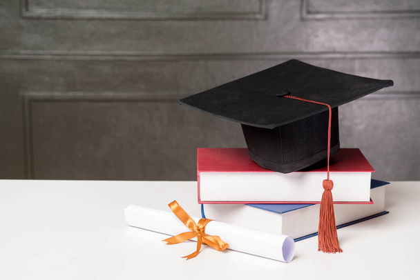 Graduation cap with books on white desk , Education background  - Fotó, kép