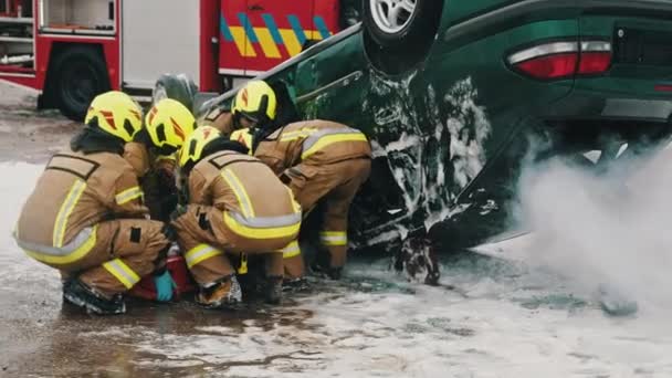 Palomiehet pelastavat loukkaantuneen henkilön auto-onnettomuuden jälkeen. Hidastus - Materiaali, video