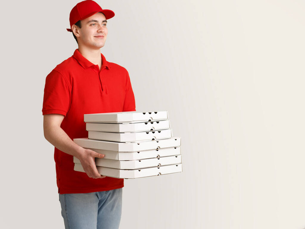 Огромный заказ пиццы для вечеринки. Курьер держит много коробок
 - Фото, изображение