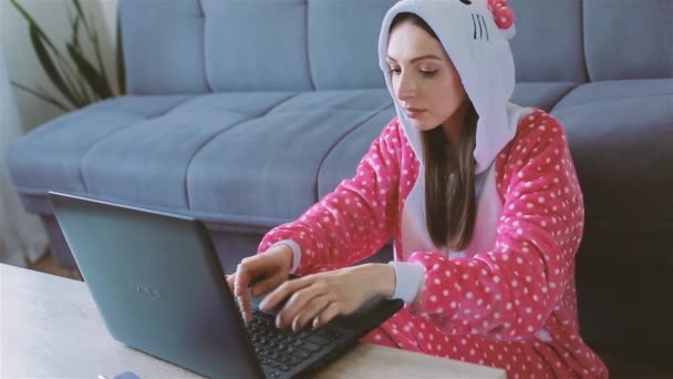 Young woman in funny pajama working from home - Filmati, video
