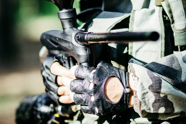 Hands of a young special forces soldier in leather gloves and weapons - Фото, изображение