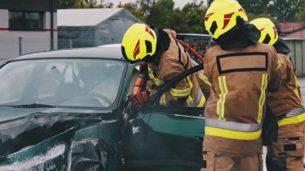 Firefighters cutting car door open at scene of car accident. Slow motion - Footage, Video