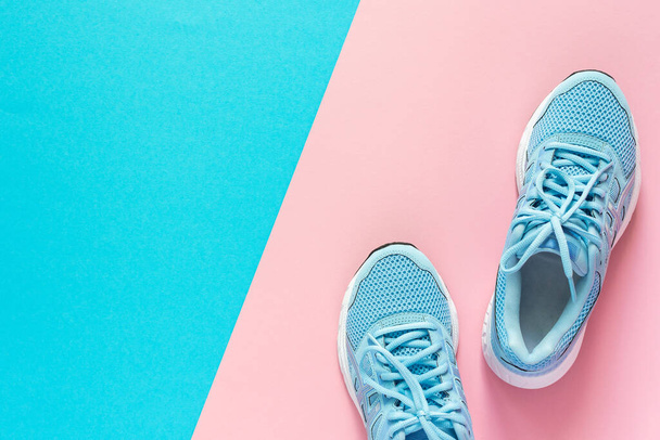 Baskets bleues isolées sur fond rose et bleu, chaussures de saison pour la marche et le sport, espace pour copier, vue sur le dessus
 - Photo, image