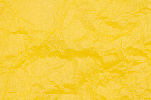 Gele gerimpelde getextureerde papieren achtergrond met kopieerruimte voor boodschap of gebruik als textuur  - Foto, afbeelding