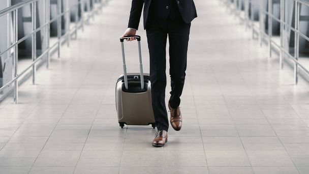 Urban business man walking in airport with suitcase - Fotó, kép