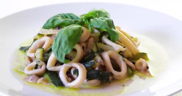 Squid en courgette klaar om te eten. Squid gesneden in cirkels en gekookt in een pan met courgettes, met olijfolie en basilicum. Italiaanse keuken - Video