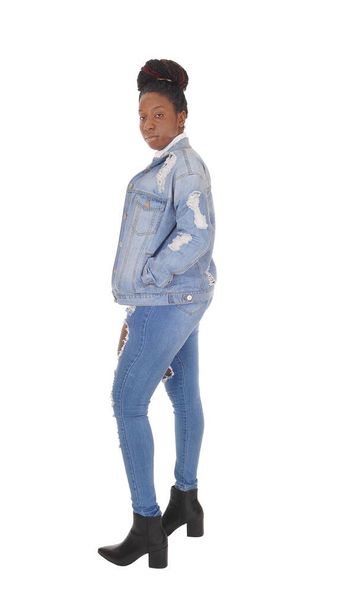 A young African American woman standing in ripped jeans and  - Foto, afbeelding