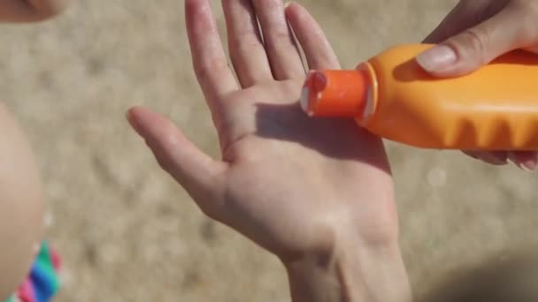 Vrouw knijpt zonnebrandcrème uit een buis op haar hand. - Video