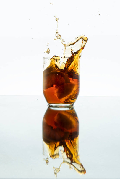 新鮮な飲み物とレモンとガラスに氷を振りかける - 写真・画像