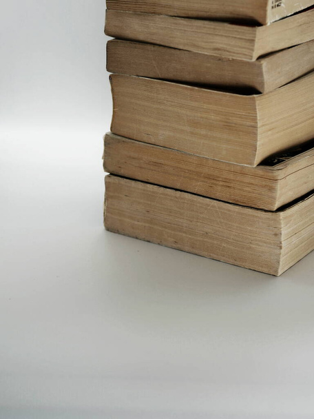 Stapel gebrauchter alter Taschenbücher mit Kopierraum und grauem Hintergrund - Foto, Bild