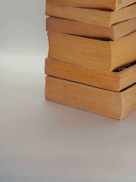 Куча старых книг в мягкой обложке с копировальным пространством и серым фоном
 - Фото, изображение