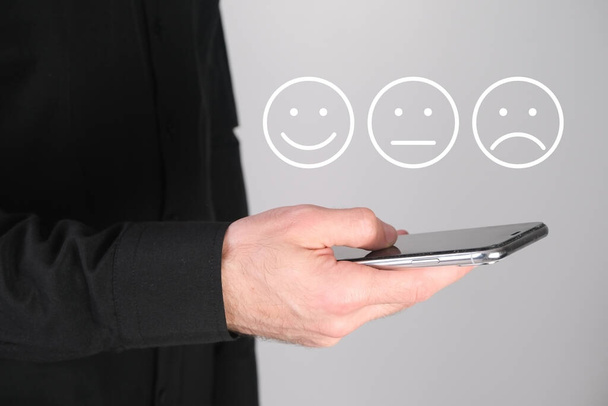 Man giving rating, leaving review with a happy face emotion icon. Product quality survey. Feedback concept. - Fotografie, Obrázek